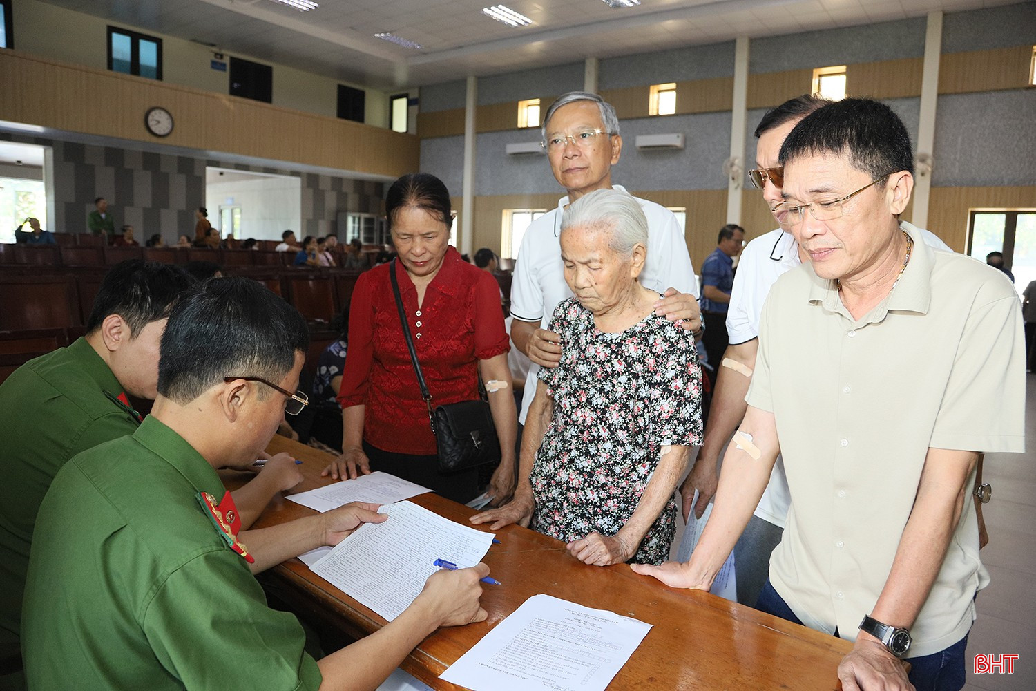 Ông Nguyễn Trọng Thịnh (ngoài cùng bên phải) thực hiện các bước theo hướng dẫn để hoàn tất thủ tục thu nhận mẫu ADN. bqbht_br_a2.jpg